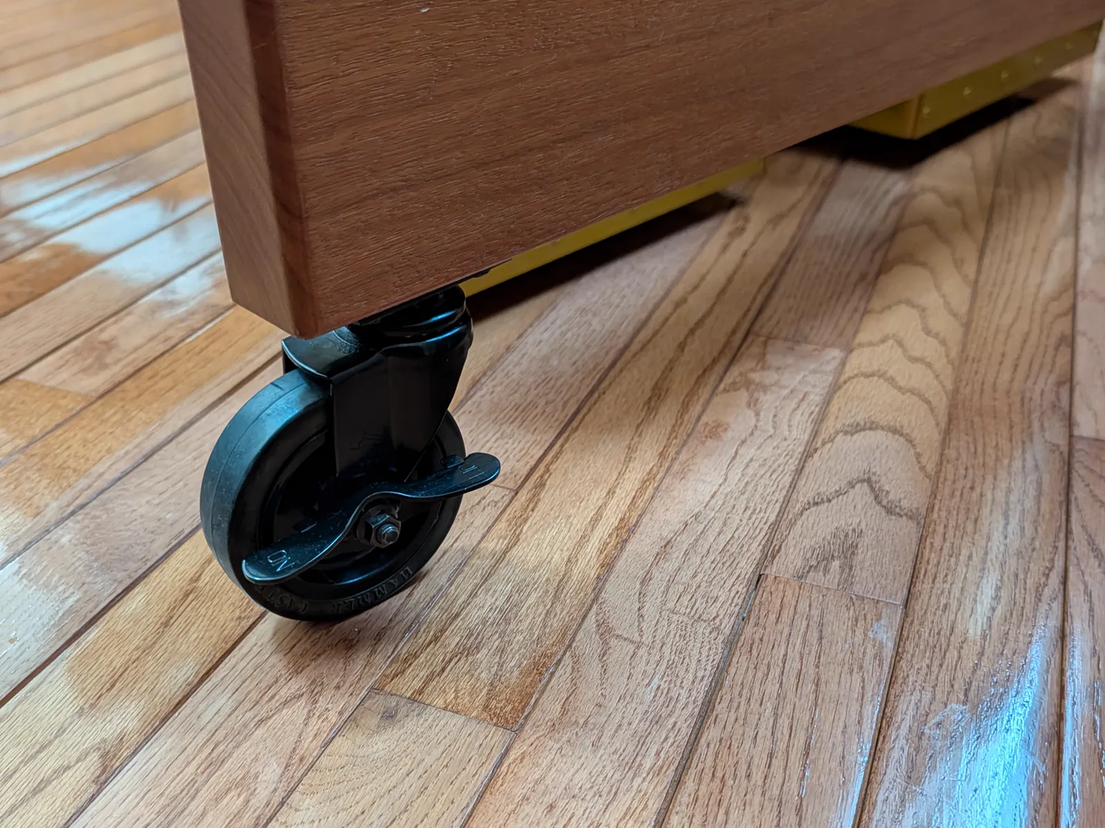Caster on a concert marimba frame, with the wheel and foot-operated stopper numbered