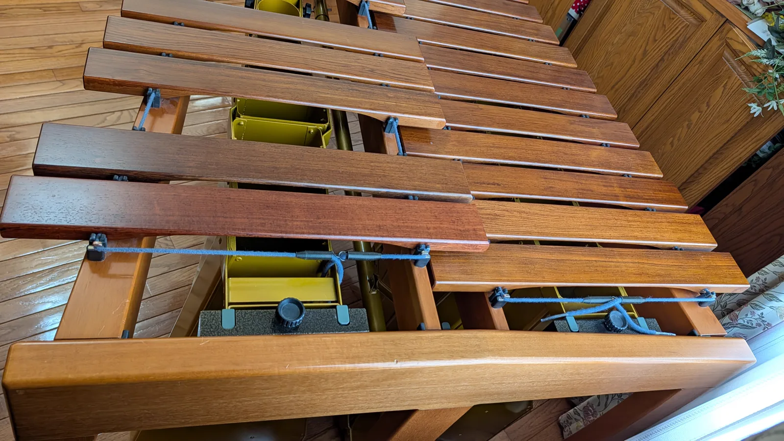 Close view showing the suspension cord, bar-support posts, rail, and both rows of bars